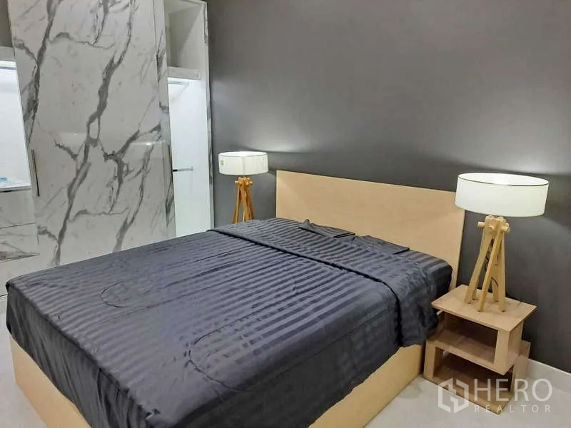 公寓 出租在Khlong Toei, Bangkok - 主卧配深色背景墙，灰色床品，三脚落地灯及大理石衣柜。