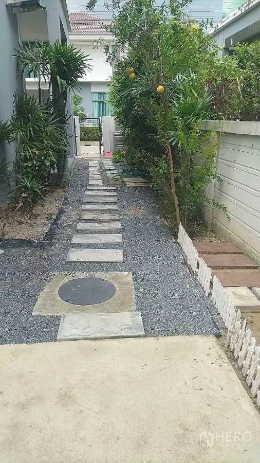 独立式住宅 出售在Lat Krabang, Bangkok - 屋侧花园小径，碎石与踏步铺就，两侧绿植环绕。