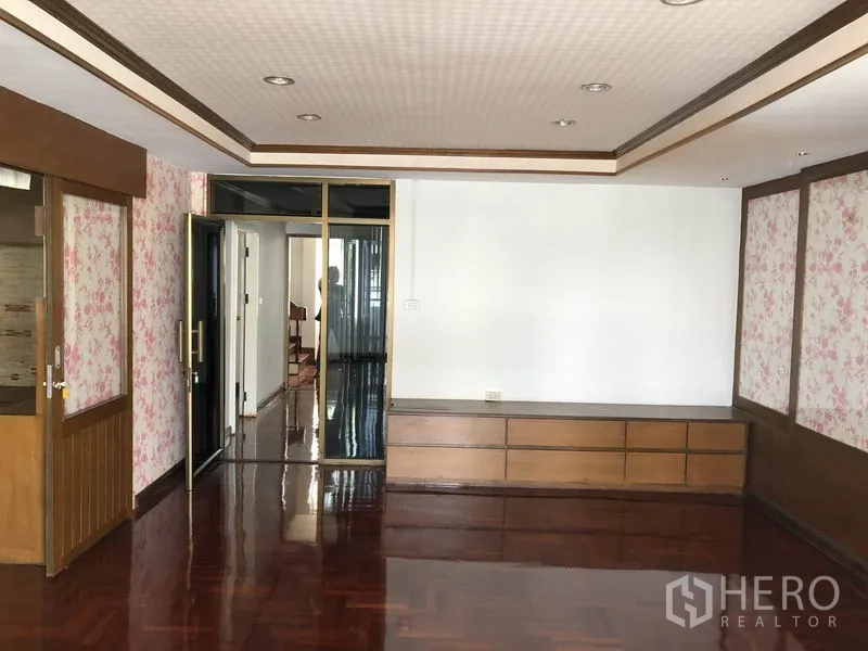 带办公室的家 出租在Huai Khwang, Bangkok - 起居区带木质内置柜、花纹墙面与高光拼花木地板。