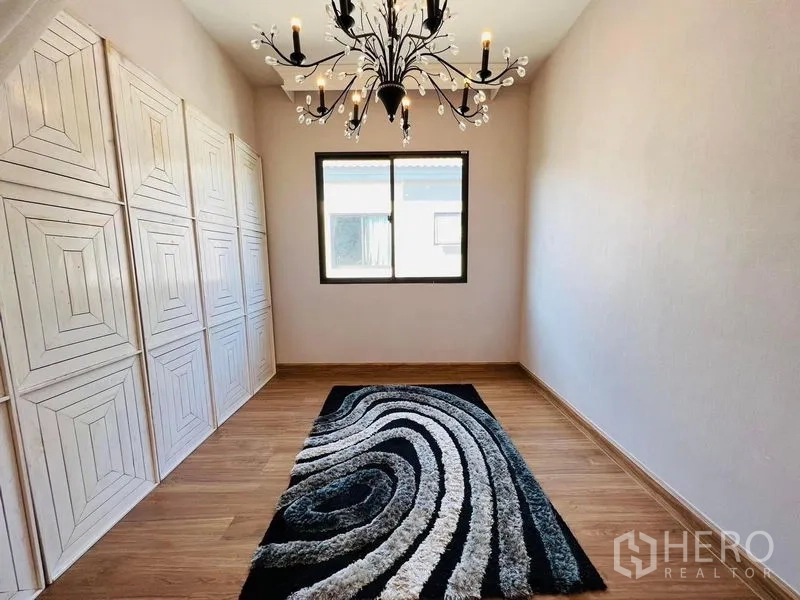 Detached House for rent or sale in Bang Khen, Bangkok - Multipurpose room with built-in wardrobes, modern chandelier and patterned rug.