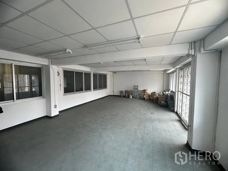 Factory for rent or sale in Khlong Luang, Pathum Thani - Large office room with grid ceiling, windows and natural light.