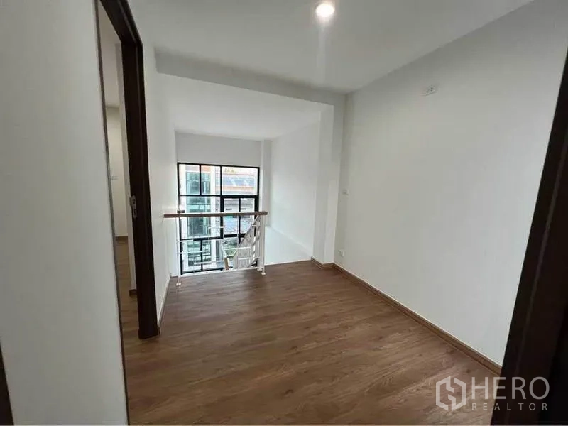 Home Office for rent in Bang Phli, Samut Prakan - Stair landing with window and metal-and-glass railing bringing natural light inside.