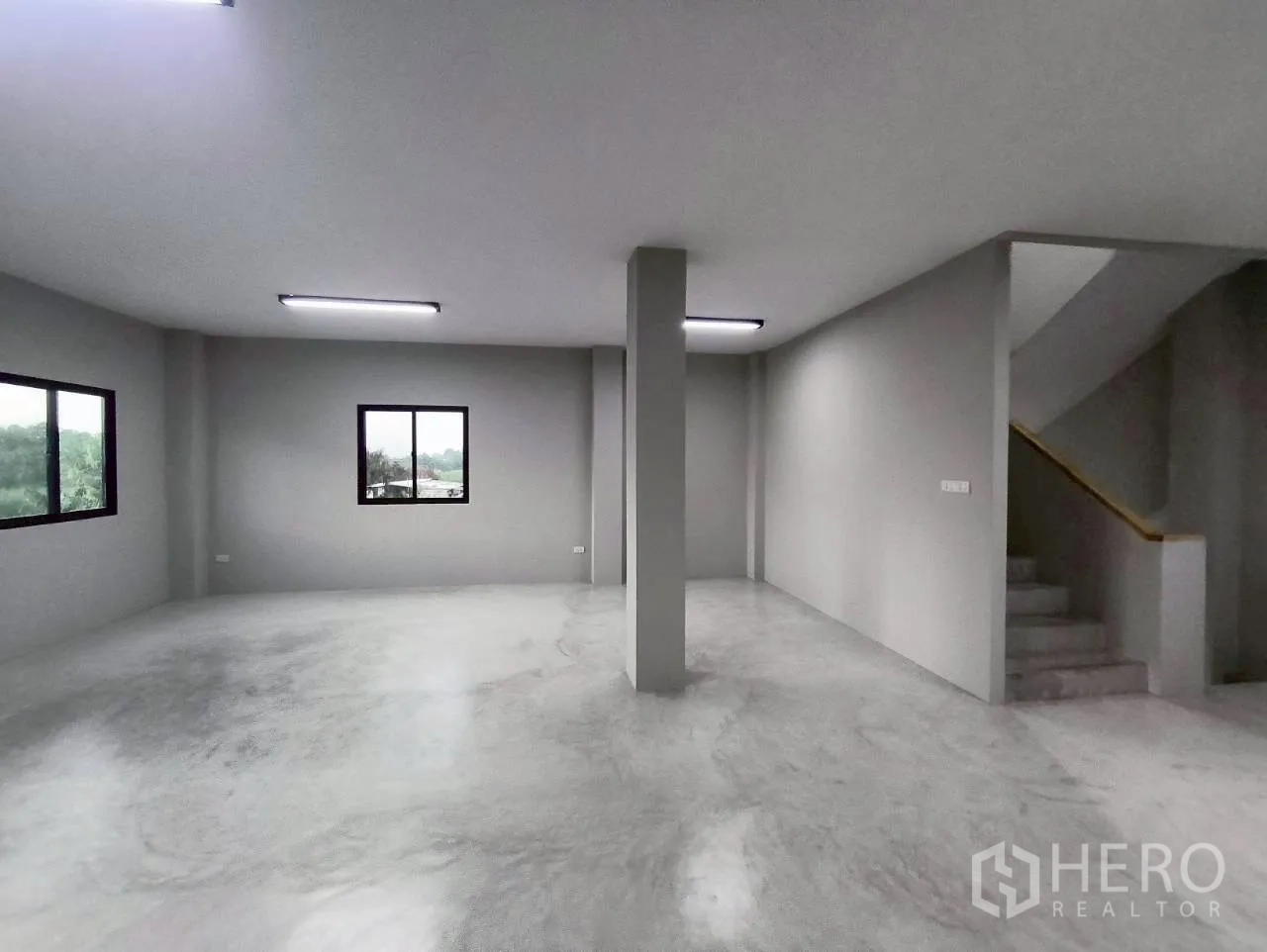Warehouse for rent in Mueang Nonthaburi, Nonthaburi - Open office-style space with windows, central column, and stair access.
