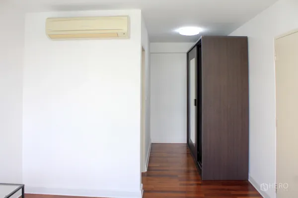 Condominium for rent or sale in Watthana, Bangkok - Bright hallway with wooden floors, wall air conditioner and a dark mirrored wardrobe.