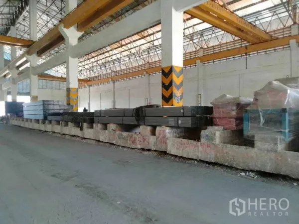 คลังสินค้า ให้เช่าหรือขายในBan Phaeo, Samut Sakhon - คานเครนสีเหลืองและวัสดุเหล็กวางบนแท่นภายในโกดัง