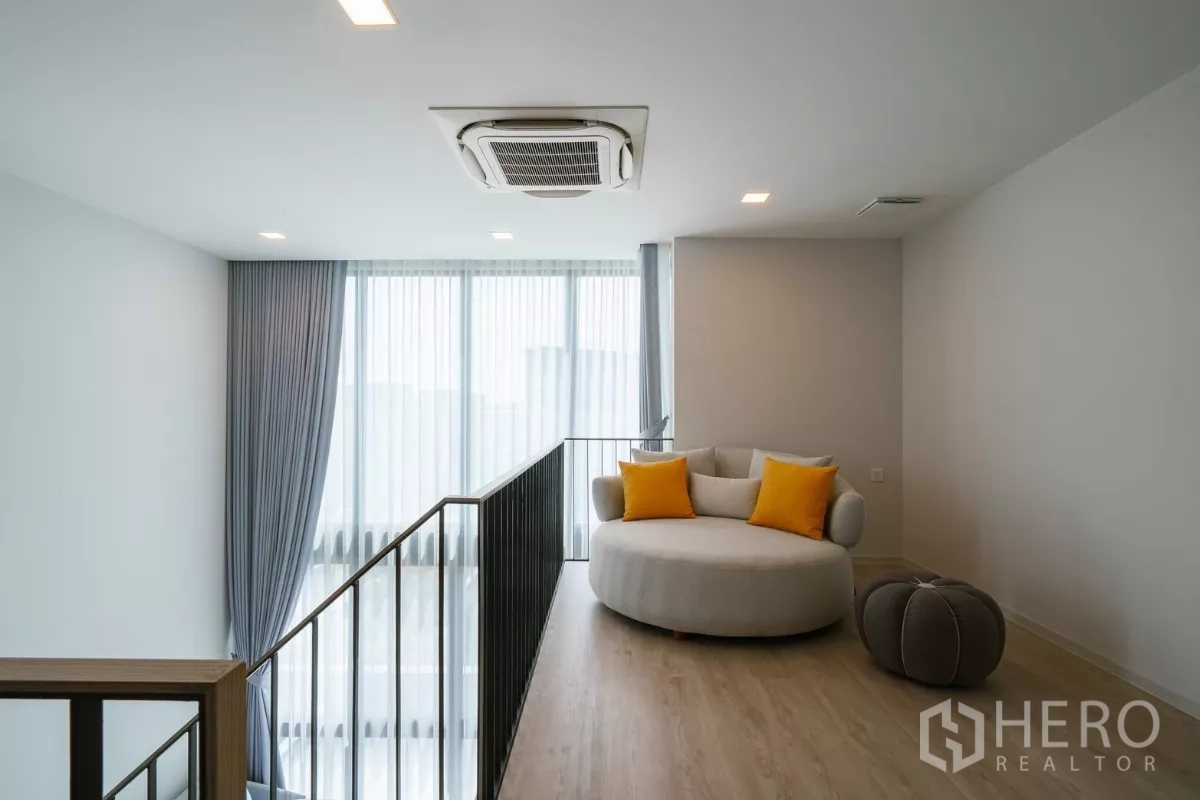 Detached House for rent or sale in Saphan Sung, Bangkok - Upper loft lounge with round daybed, ottoman and large windows.