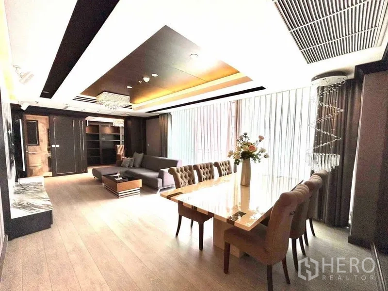 公寓 出售在Watthana, Bangkok - 明亮餐区，长石面餐桌、沙发与轻柔窗帘。