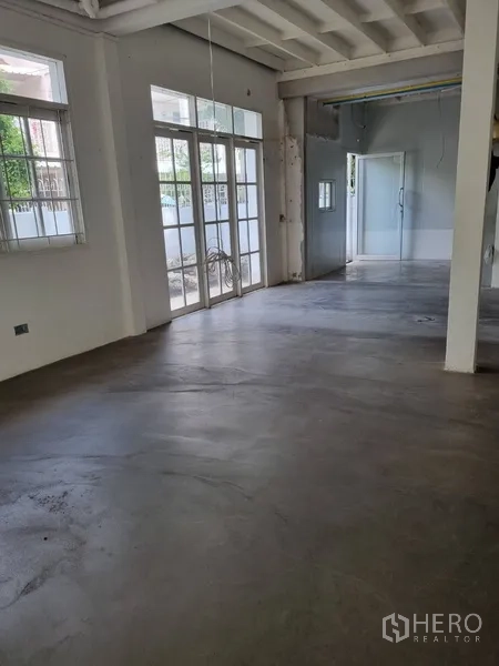 独立式住宅 出租或出售在Sathon, Bangkok - 走廊望向客厅，设有推拉玻璃隔断与多窗采光。