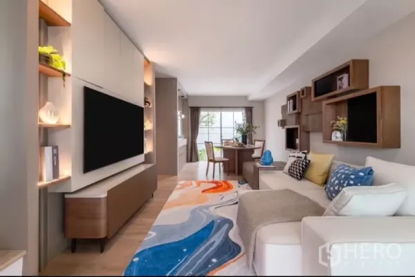Townhouse for rent in Bang Phli, Samut Prakan - Bright open‑plan living room with large TV wall, sectional sofa and dining area.