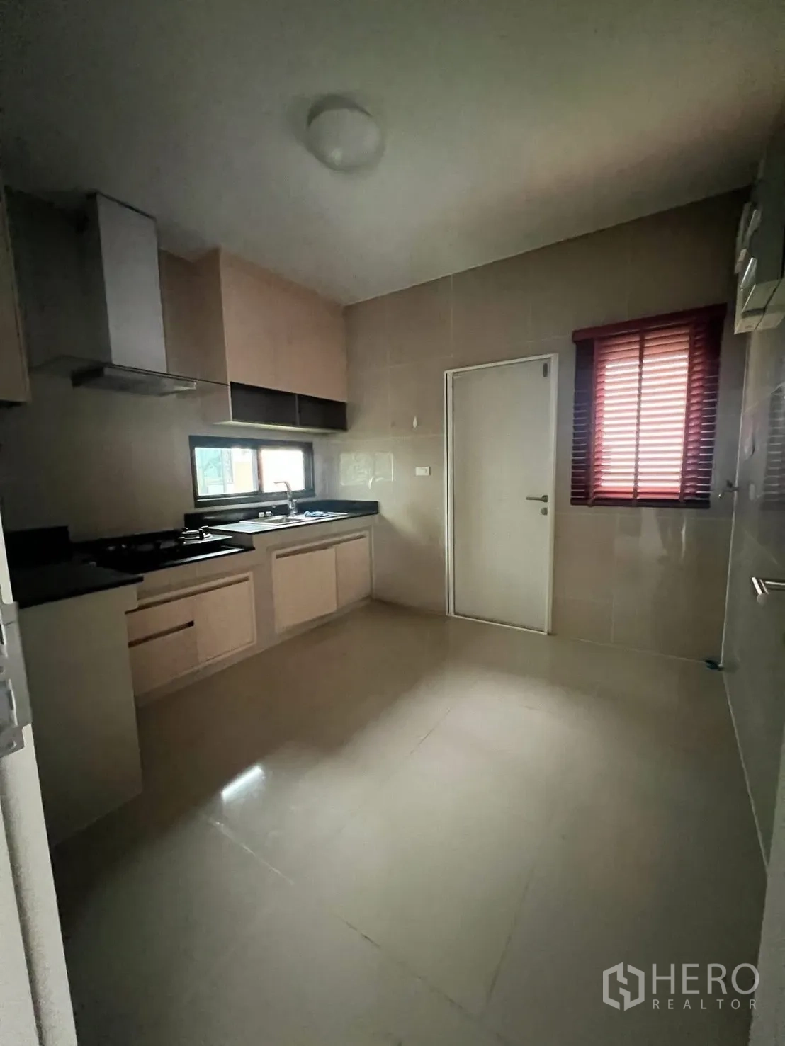 Detached House for rent in Bang Phli, Samut Prakan - Fitted kitchen with gas hob, range hood, window, and built-in cabinets.