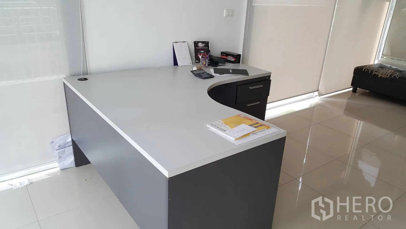 公寓 出租在Pathum Wan, Bangkok - 整洁的办公角，L 形书桌、计算器与卷帘窗