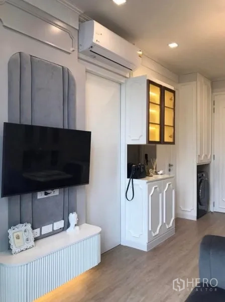 Condominium for rent in Watthana, Bangkok - TV feature wall with air conditioner and illuminated display cabinet in the lounge