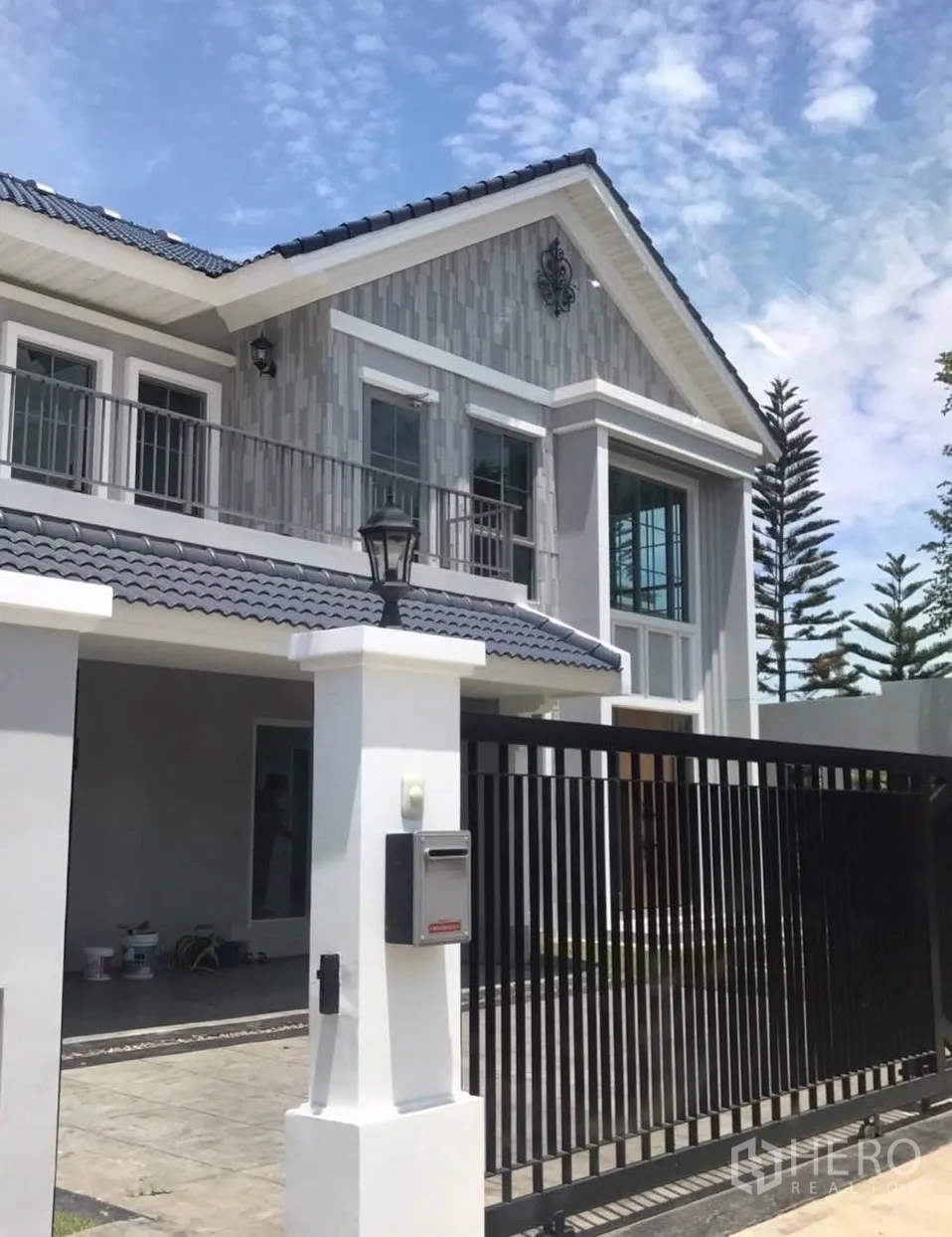 บ้านเดี่ยว for rent in Bang Phli, Samut Prakan - บ้านเดี่ยวสองชั้นสไตล์โมเดิร์น โทนเทา มีระเบียงและรั้วเหล็กสีดำด้านหน้า
