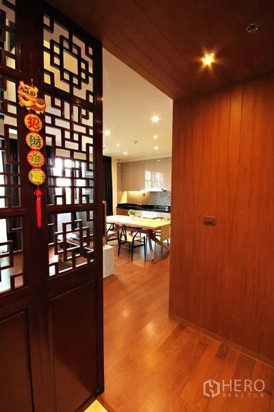 Condominium for rent or sale in Khlong Toei, Bangkok - Ornate wooden door with Chinese lattice leading to the living-dining area.