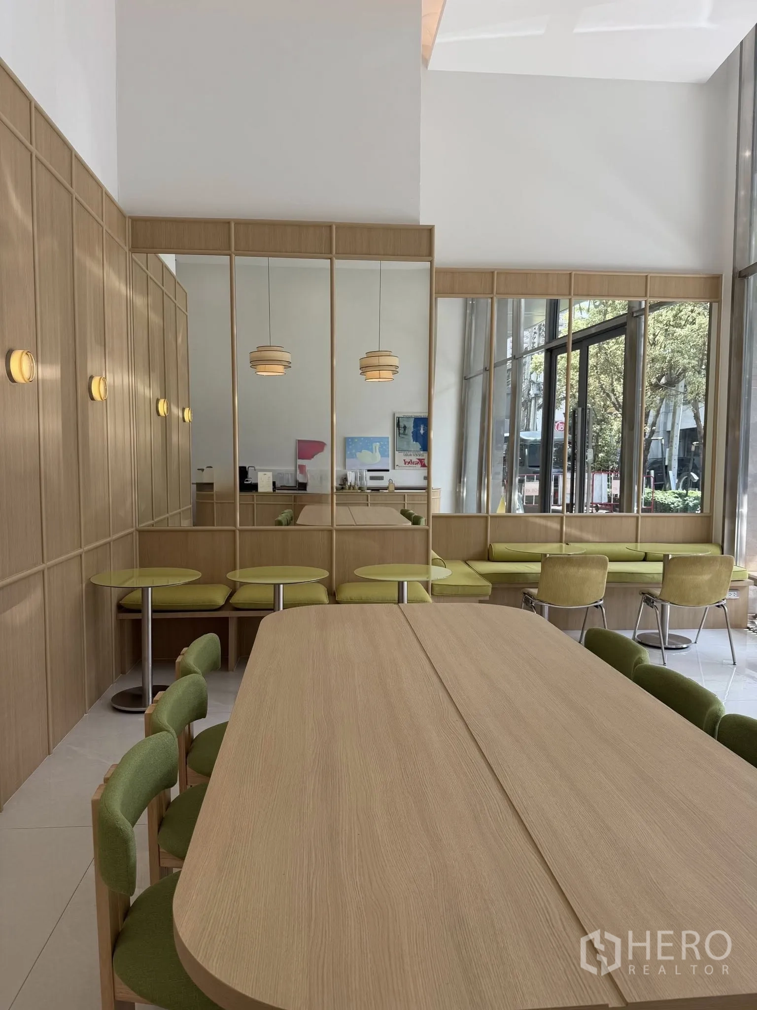 Retail Space for rent in Watthana, Bangkok - Bright retail interior with high ceiling, wood finishes, green seating, and floor-to-ceiling windows.