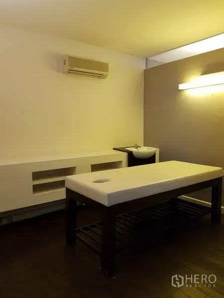 Retail Space for rent in Khlong Toei, Bangkok - Private treatment room with massage table, sink, wall light and air conditioning.