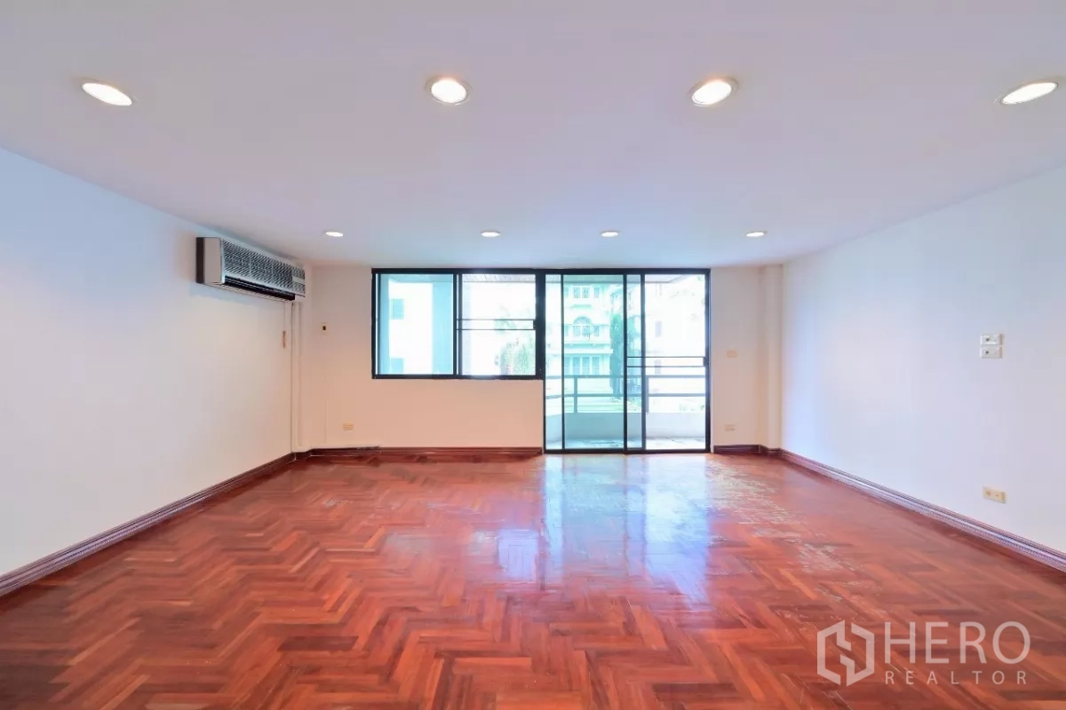 联排别墅 出售在Watthana, Bangkok - 宽敞客厅，拼花木地板，筒灯照明，落地玻璃门连通阳台。