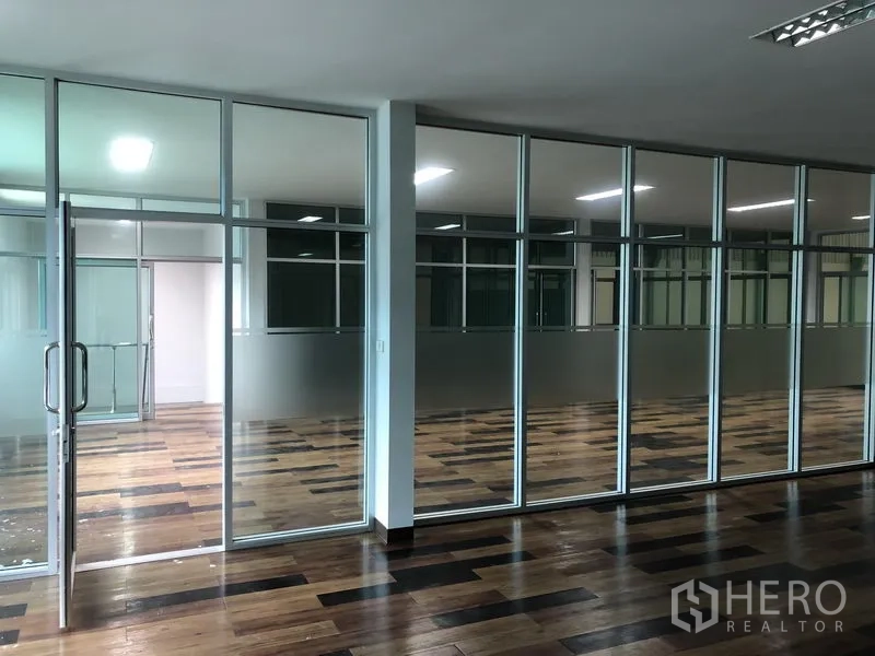 Factory for rent in Samut Prakan - Meeting and office rooms divided by large glass partitions and sliding doors.