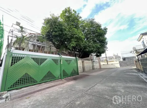 Home Office for rent in Lat Phrao, Bangkok - Green metal gate of a renovated two-storey home office on a quiet Lat Phrao lane