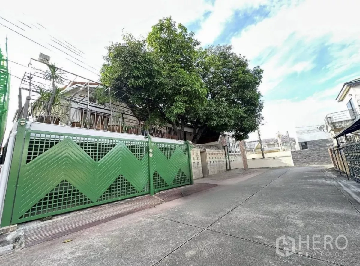 Home Office for rent in Lat Phrao, Bangkok - Green metal gate of a renovated two-storey home office on a quiet Lat Phrao lane