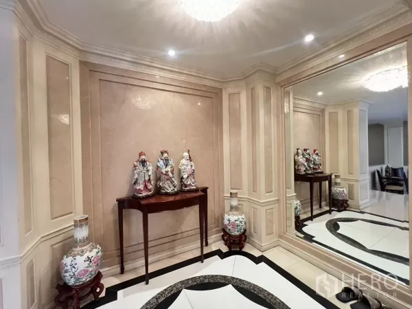 Townhouse for sale in Watthana, Bangkok - Elegant foyer with marble wall panels, display console and large wall mirror.