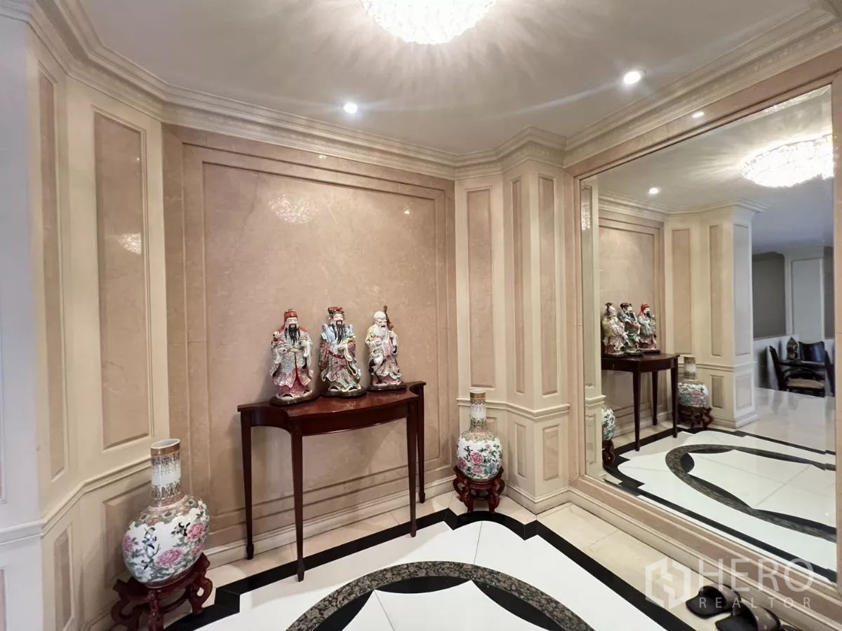 Townhouse for sale in Watthana, Bangkok - Elegant foyer with marble wall panels, display console and large wall mirror.