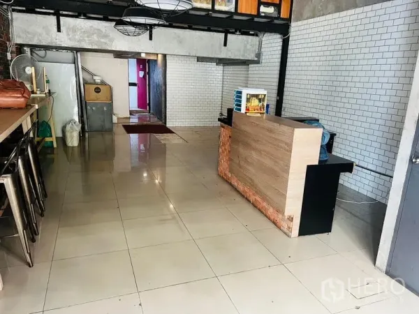 零售空间 出租在Watthana, Bangkok - 开放式店铺地面，抛光地砖，接待台与地铁砖墙面，通往后场的通道。