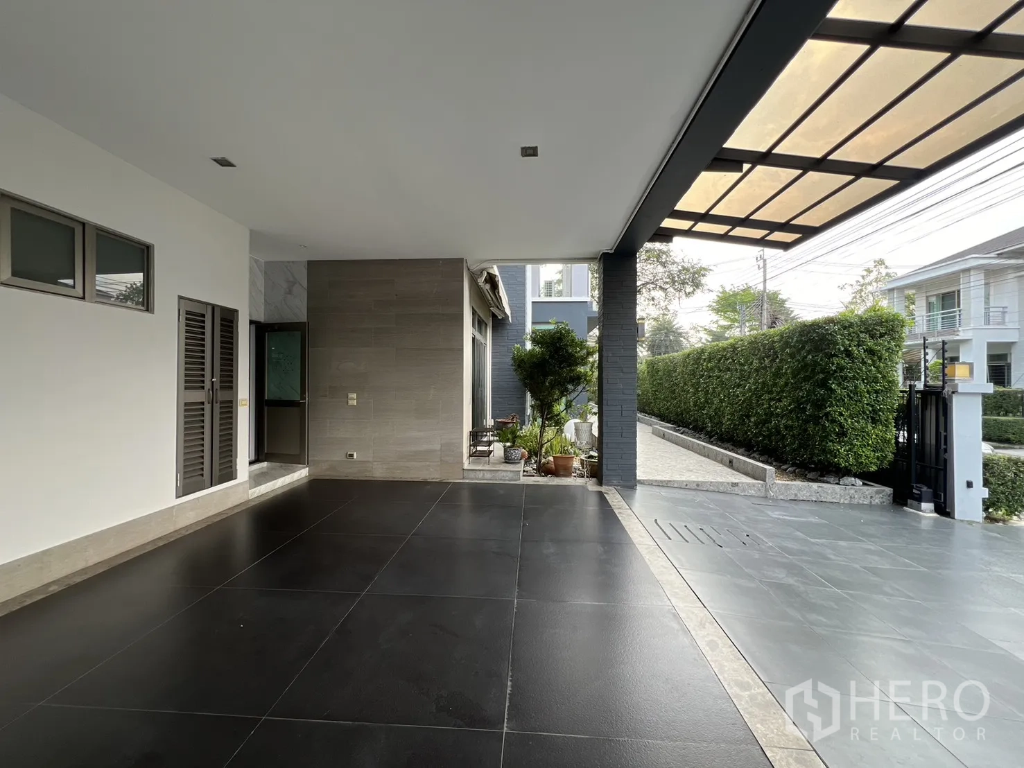 บ้านเดี่ยว for rent in Prawet, Bangkok - ที่จอดรถในร่ม พื้นกระเบื้องสีเข้ม พร้อมรั้วและประตูทางเข้าในซอยเงียบ