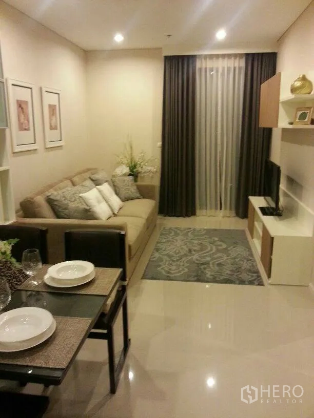 公寓 出租在Ratchathewi, Bangkok - 温馨客餐厅，沙发、电视柜与带遮光窗帘的落地推拉门。