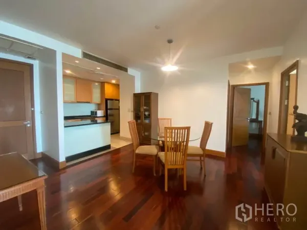 公寓 出租在Sathon, Bangkok - 餐厅四人座，吊灯照明，旁有通往卧室的走道与开放式厨房。