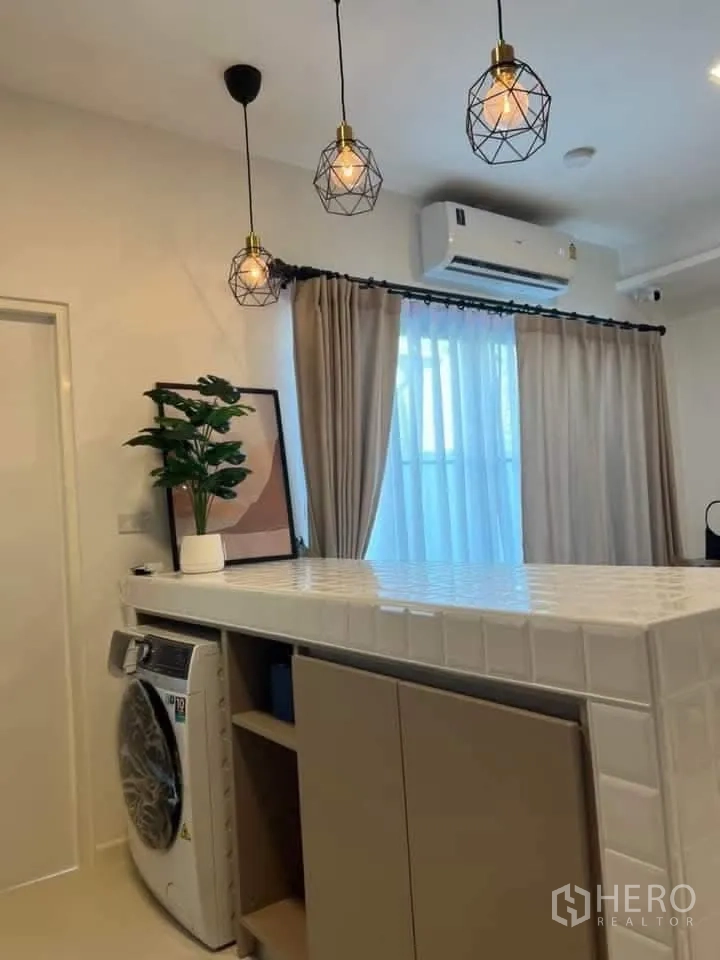 Townhouse for rent in Bang Phli, Samut Prakan - Breakfast bar with geometric pendant lights and a washing machine niche beneath.