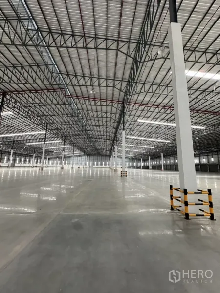 工厂 出租在Chon Buri - 开放式生产区，钢桁架屋顶、LED照明与柱脚防护。