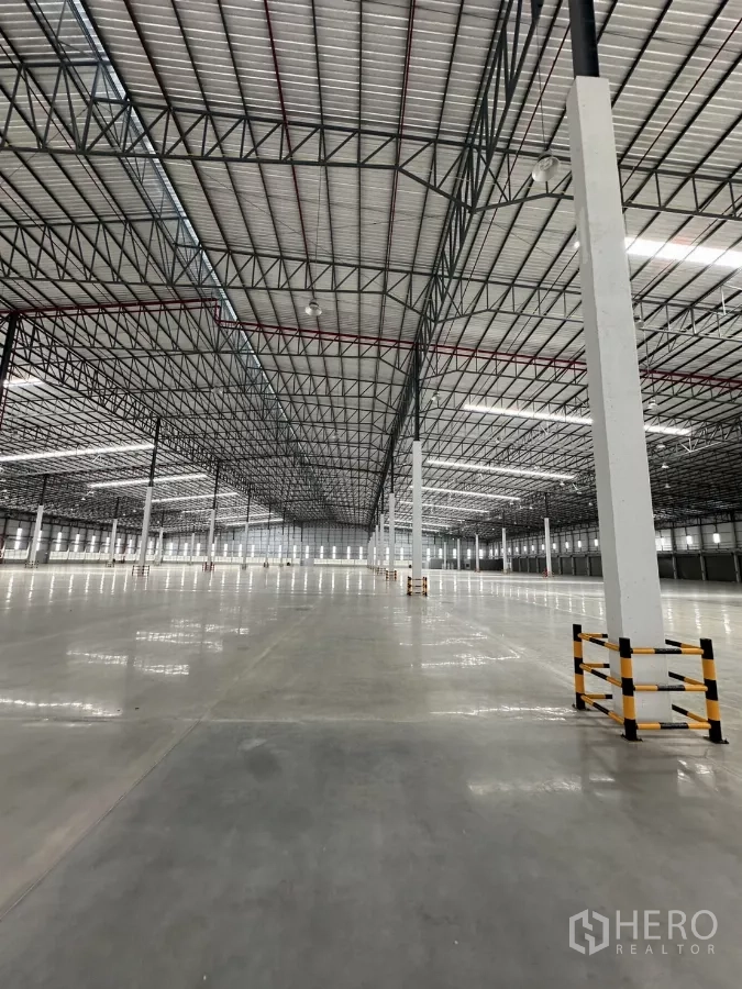 工厂 出租在Chon Buri - 开放式生产区，钢桁架屋顶、LED照明与柱脚防护。