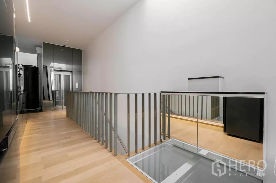 Townhouse for sale in Chatuchak, Bangkok - Upper landing with mirrored balustrade and private residential elevator.