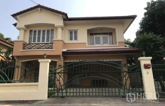 独立式住宅 出租在Khlong Sam Wa, Bangkok - 两层独栋别墅外立面，带铁艺大门与有顶车位，拱形窗