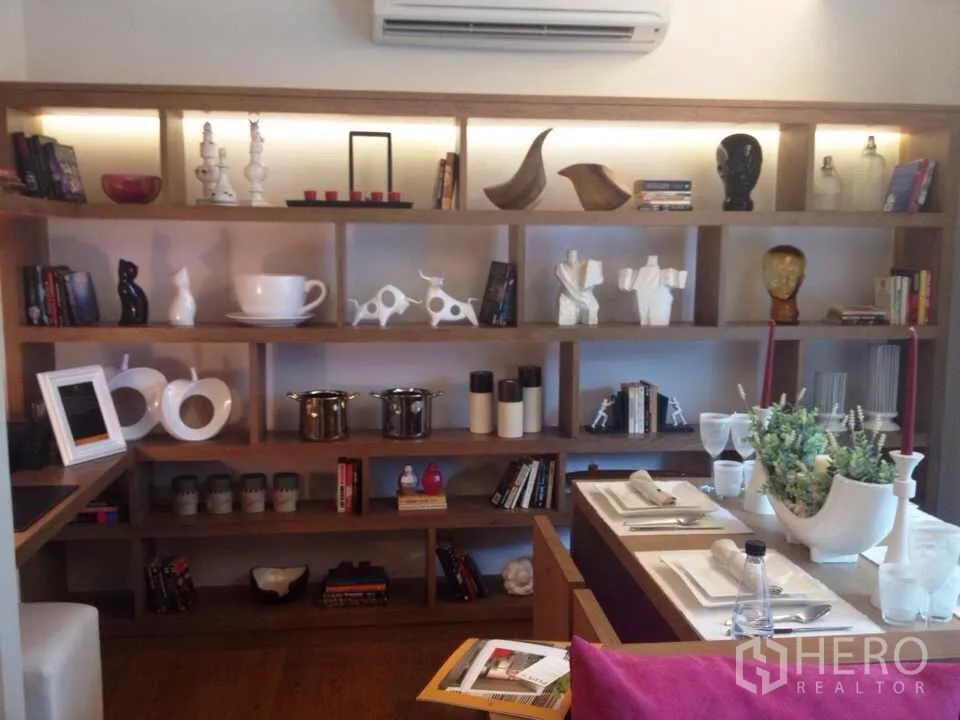 公寓 出租在Watthana, Bangkok - 用餐角落与整面发光木架一览，上方装有空调。