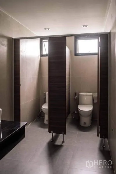 Home Office for rent or sale in Lak Si, Bangkok - Modern restroom with partitioned stalls and small high windows for daylight.