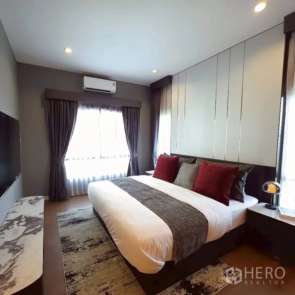 Detached House for rent in Bang Phli, Samut Prakan - Cozy bedroom with king bed, accent pillows, and a large window.
