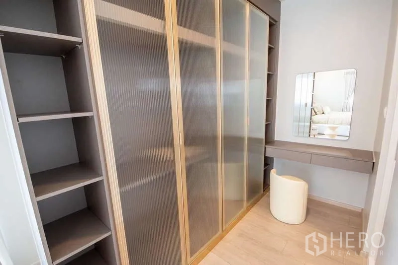 Detached House for rent in Bang Phli, Samut Prakan - Walk-in closet with frosted glass sliding wardrobes and vanity desk.