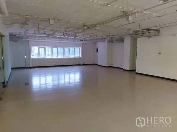 Office Space for rent in Pathum Wan, Bangkok - Open-plan office space with glossy flooring, exposed ceiling and a long window wall with city views.