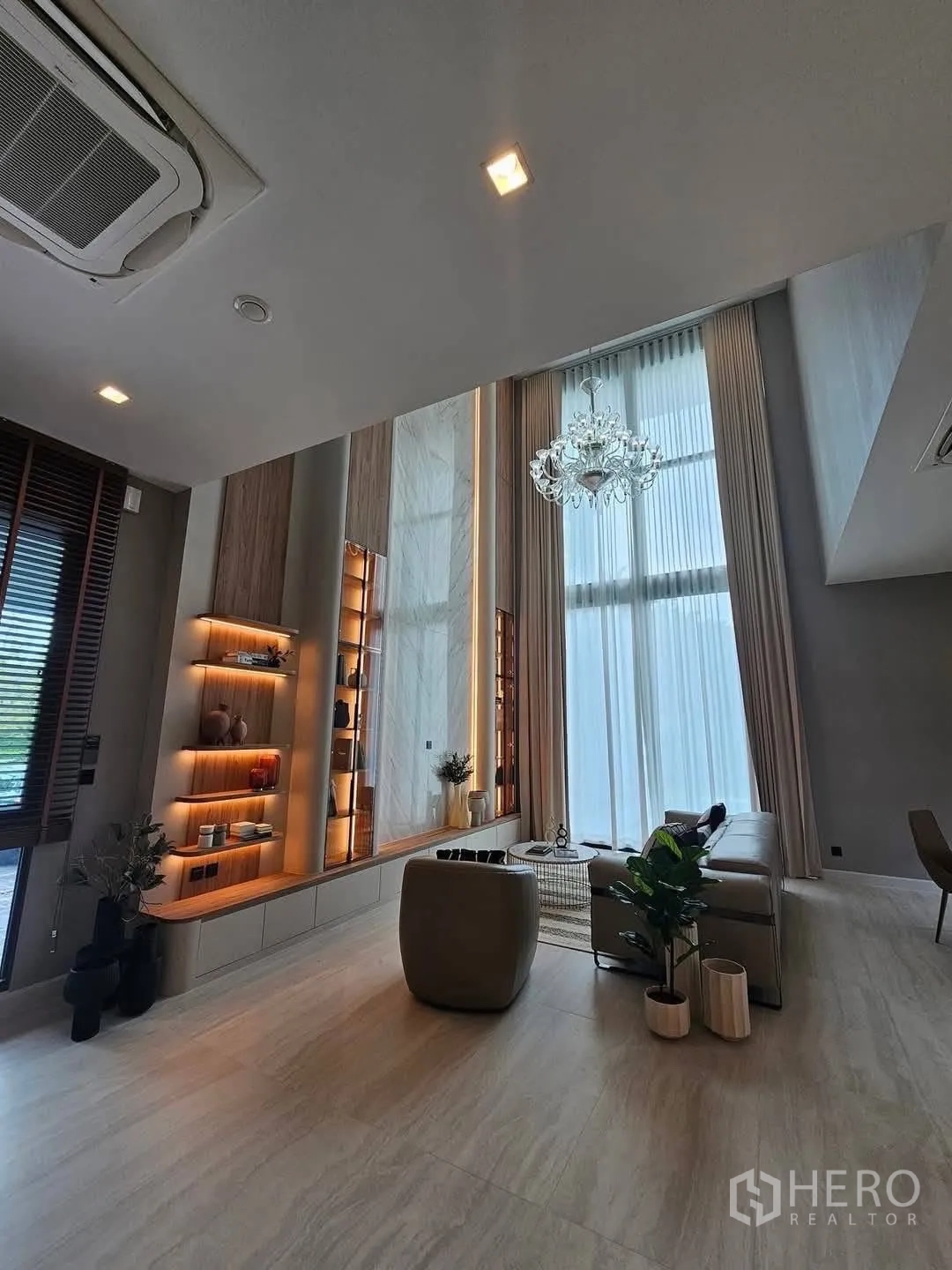 บ้านเดี่ยว for rent or sale in Suan Luang, Bangkok - ห้องนั่งเล่นเพดานสูงสองชั้นพร้อมโคมระย้าและผ้าม่านสูง