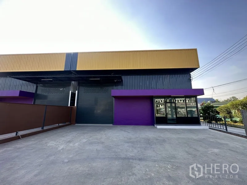 货栈 出租在Lam Luk Ka, Pathum Thani - 面向仓库的车道与装卸区，右侧为玻璃办公室。