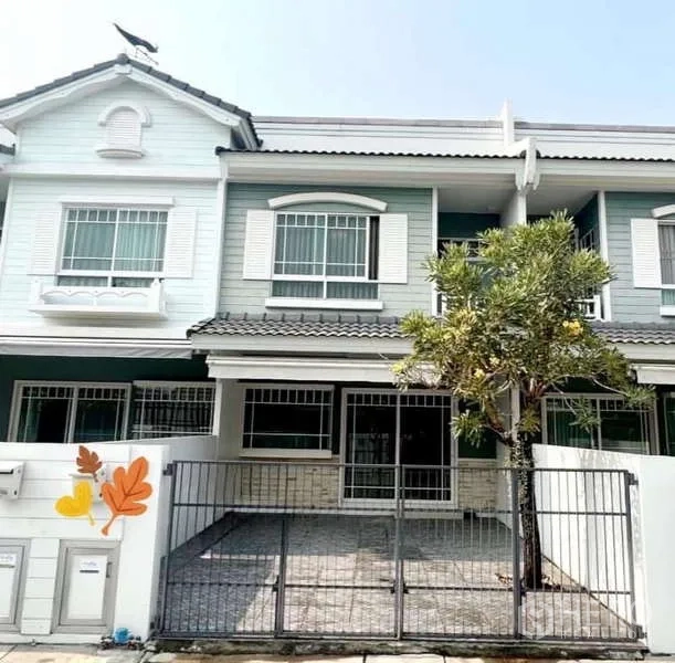 Detached House for rent in Bang Phli, Samut Prakan - Two-storey house exterior with gated parking, shuttered windows and a small tree at Indy Bangna KM7.