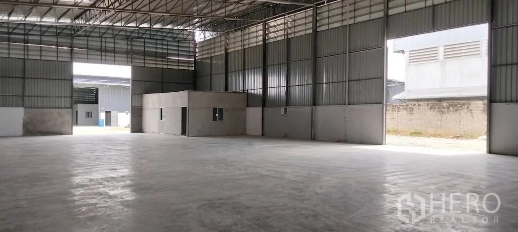 Warehouse for rent in Mueang Samut Sakhon, Samut Sakhon - High-roof warehouse interior featuring wide door openings and an internal office block.
