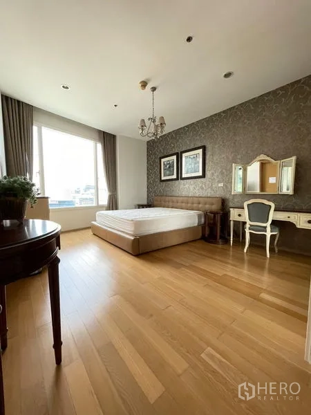 Condominium for rent in Watthana, Bangkok - Spacious master bedroom with chandelier, accent wallpaper and desk.