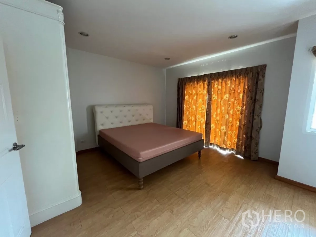 Townhouse for rent in Bang Kho Laem, Bangkok - Spacious bedroom with upholstered headboard, bed, and curtained windows.