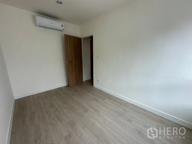 带办公室的家 出租在Khlong Toei, Bangkok - 小卧室，挂壁空调、木门与白墙。