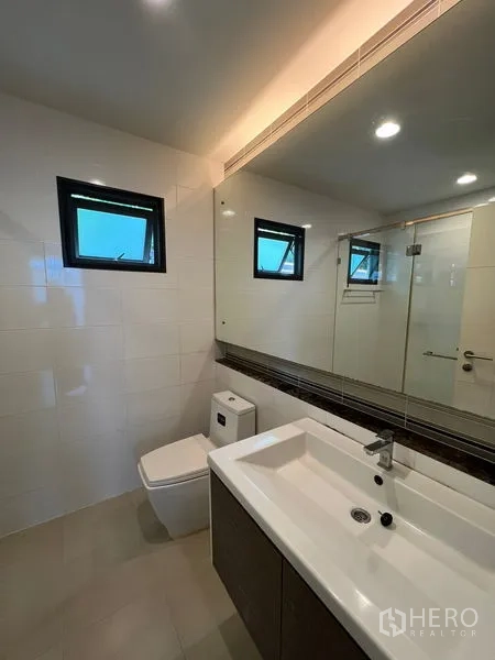 Detached House for rent or sale in Bang Kapi, Bangkok - Second bathroom with glass shower enclosure, large vanity and mirror.