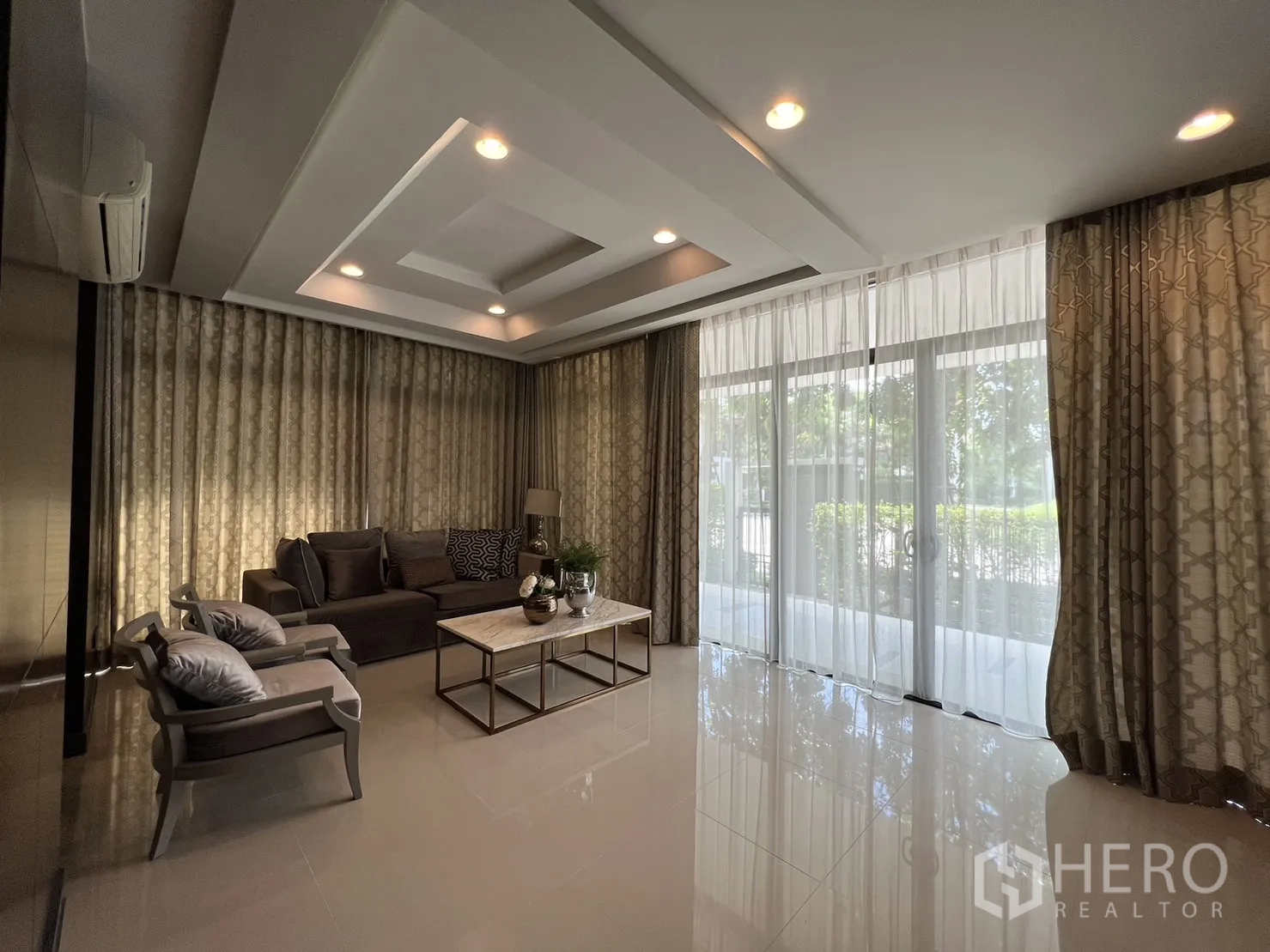 Detached House for rent or sale in Bang Kapi, Bangkok - Spacious living room with recessed ceiling lights and full-height glazing.
