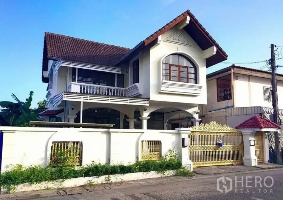 独立式住宅 出租在Khlong Toei, Bangkok - 房屋正面及入户大门视角，白色围墙与红瓦屋顶。